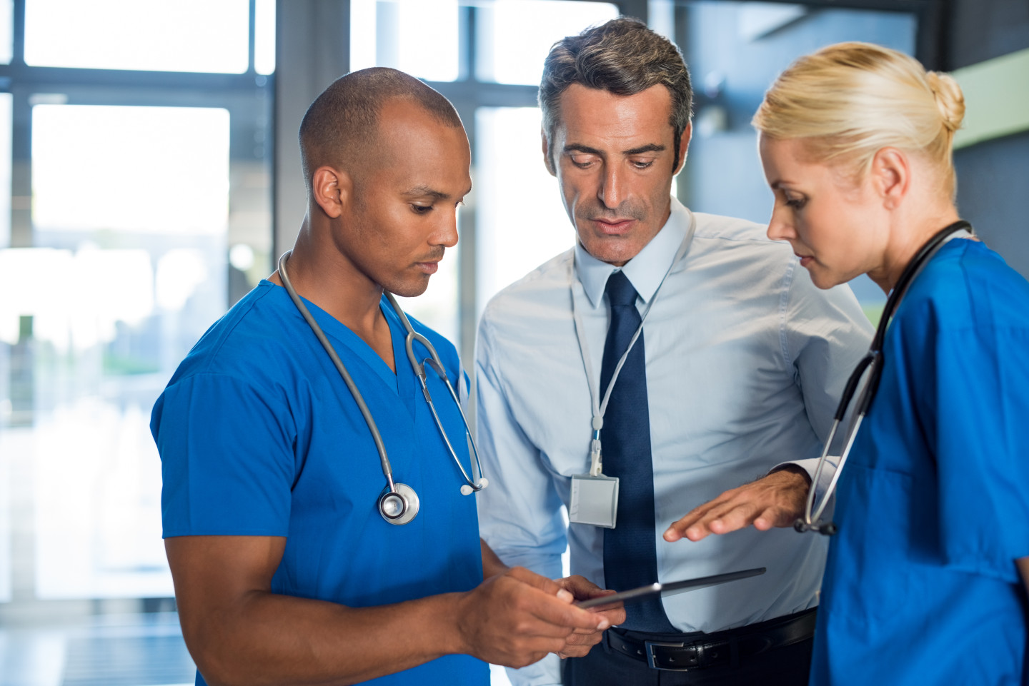Decorative image of the three health professionals looking at a tablet.
