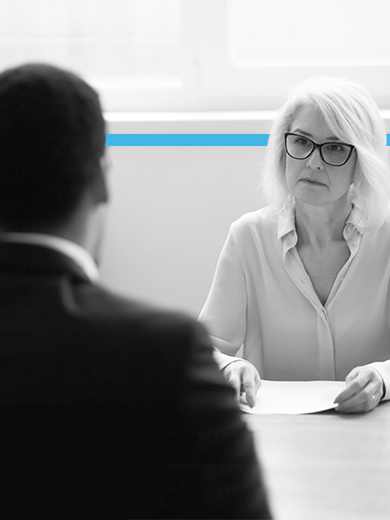 Women and man talking over paper.