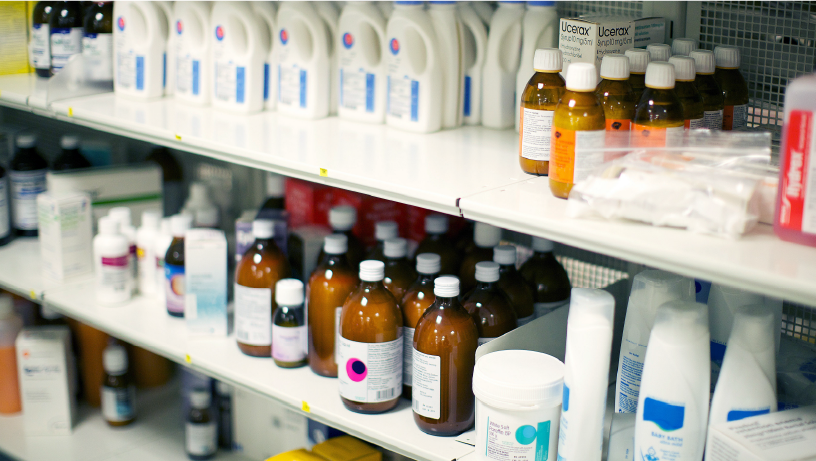 Shelves stocked with bottles, boxes, and containers of pharmaceutical products