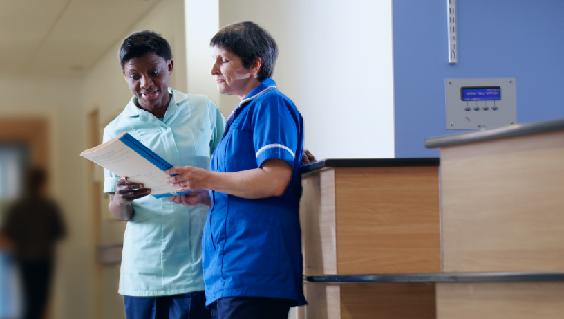 Two healthcare professionals in a hospital corridor