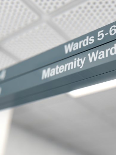 Hospital directional sign with two arrows pointing to the right, indicating directions to Wards 5–6 and the Maternity Ward